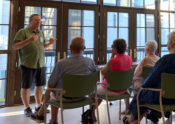 Dave Bulkowski taking questions at a neighborhood forum, with residents seated around him.