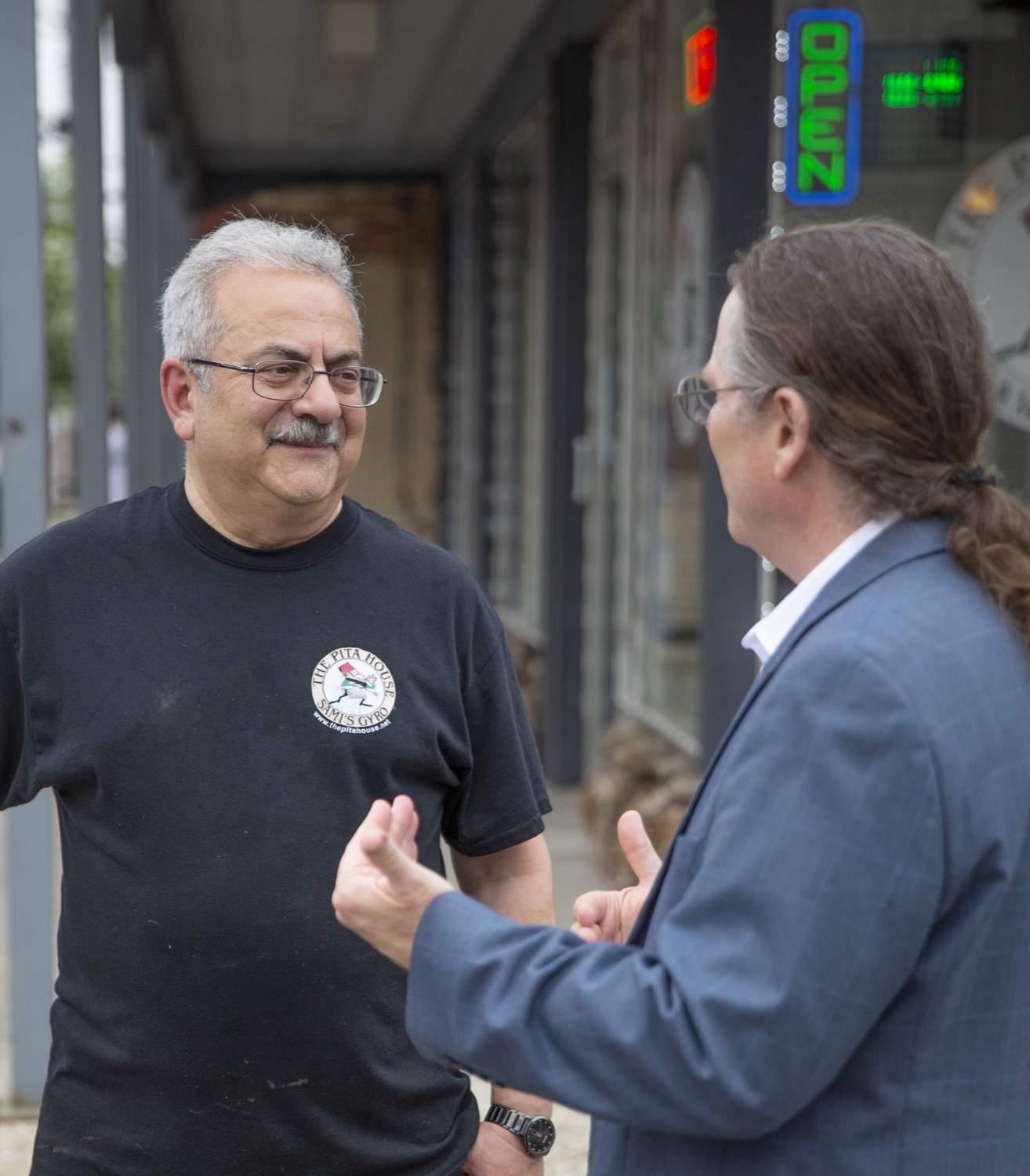 Dave Bulkowski talking with a local business owner outside a shop in Eastown, Grand Rapids.
